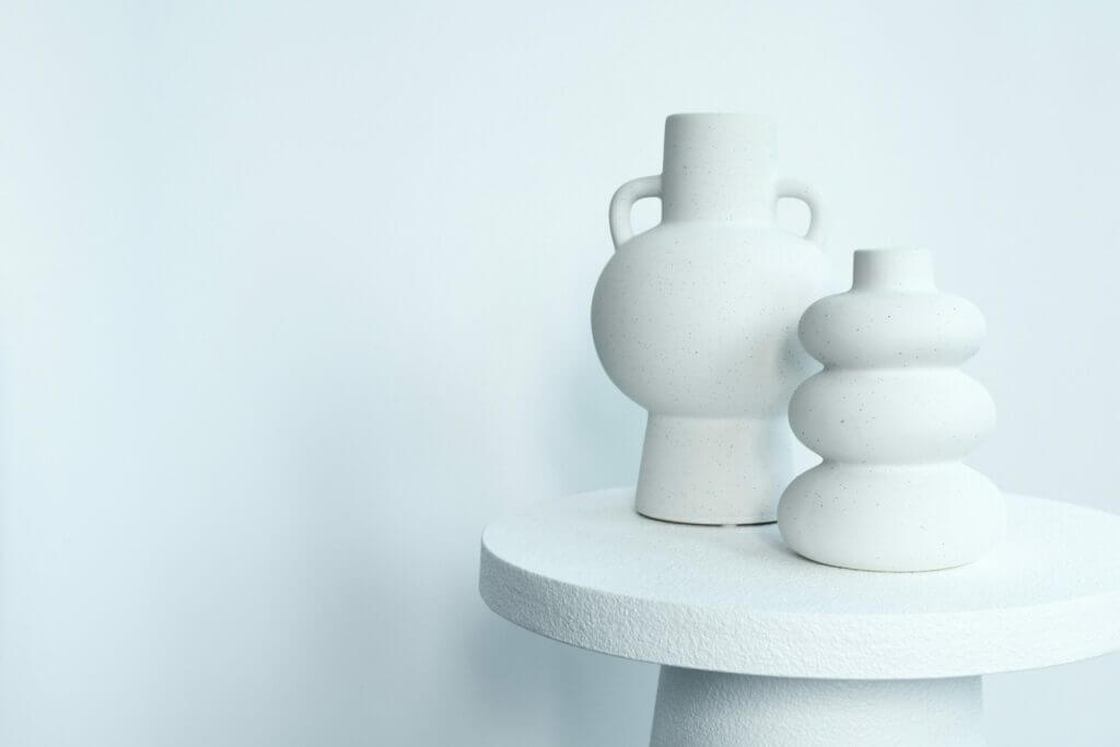 White vases on a white table. Of symbol/sample of what minimalist web design can be like