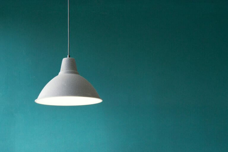 White Light hanging in front of a teal wall. Symbolizes Modern Web Design Simplicity and Focus